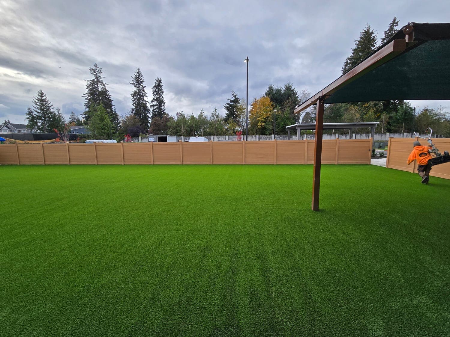 Large fenced artificial turf field for a commercial or multi-family property installed by Synthetic Turf Solutions